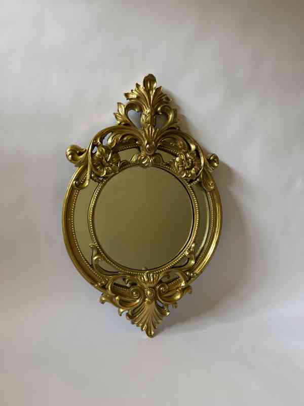 Zrcadlo ve zlatém rámu zdobeném ornamenty